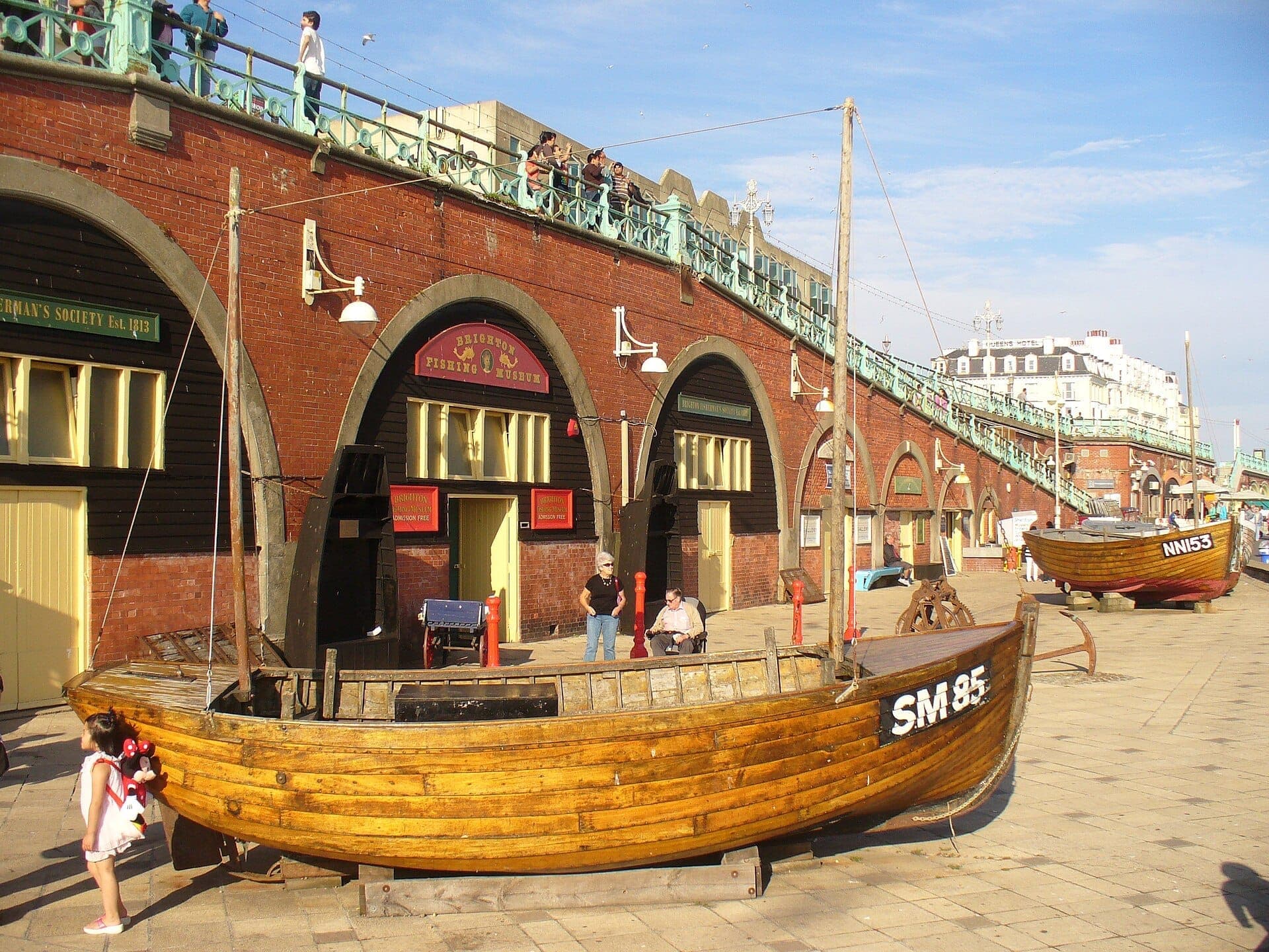 Cảnh bên ngoài Brighton Fishing Museum với những chiếc thuyền đánh cá bằng gỗ truyền thống được trưng bày trước những vòm gạch lịch sử trên bờ biển Brighton.