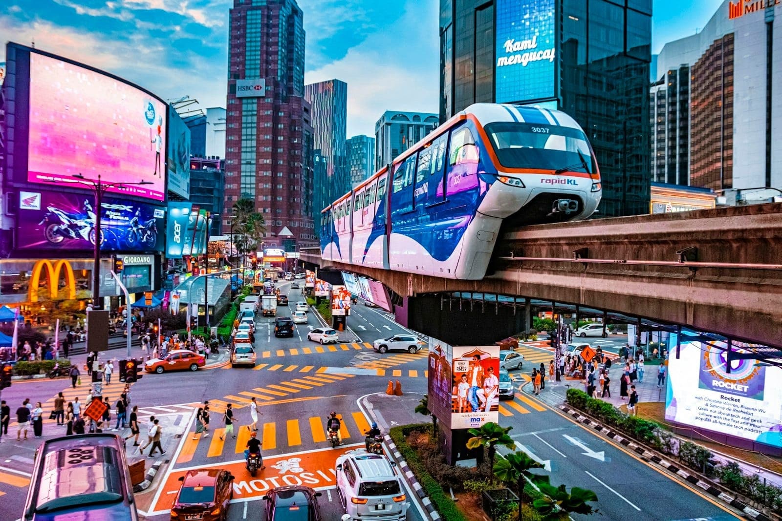 Eksena sa kalye ng Bukit Bintang na may monorail, mga neon na billboard, trapiko at distrito ng pamimili sa Kuala Lumpur