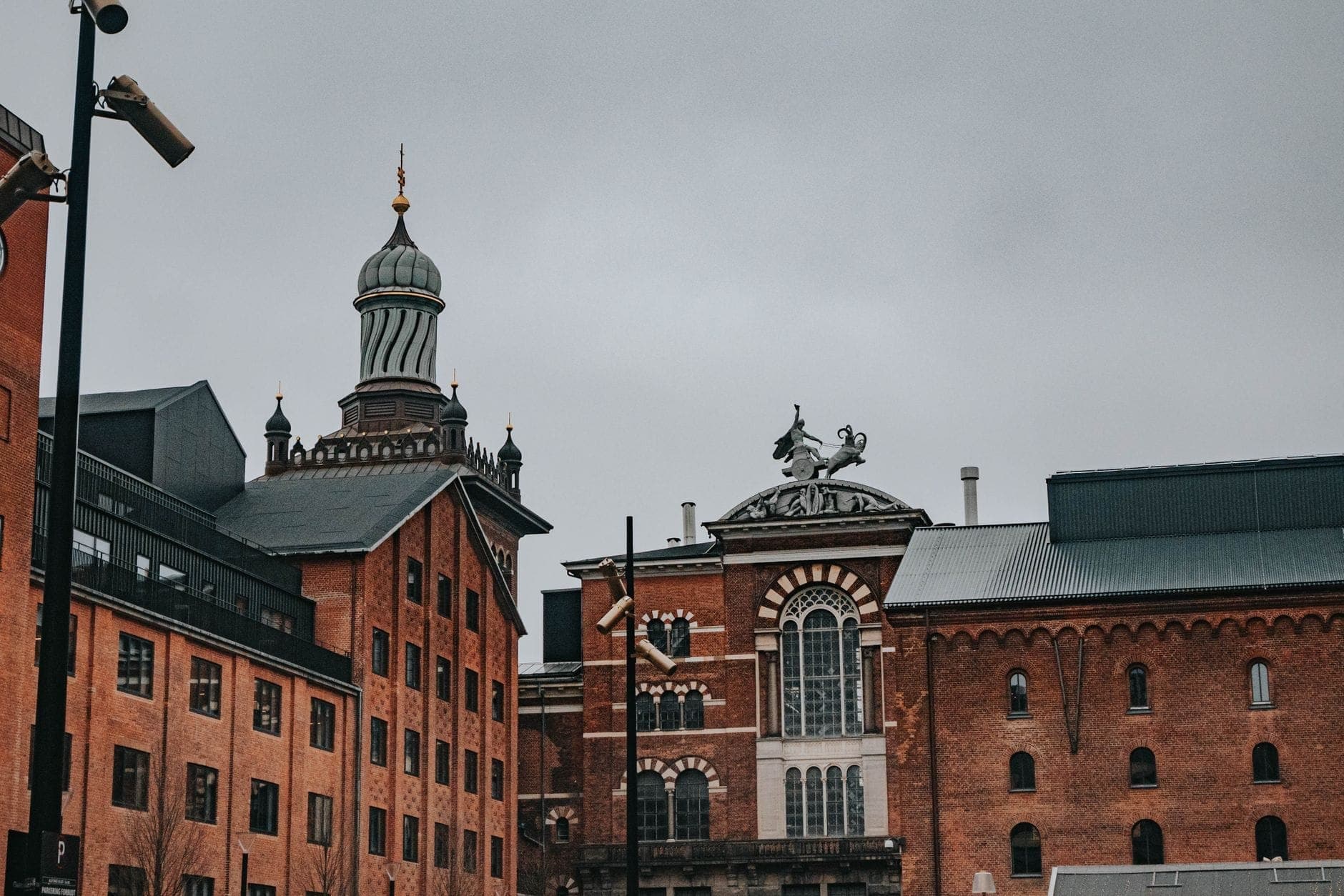 Historische rotgeklinkerte Brauereigebäude im Carlsberg-Viertel mit markanten Architekturdetails und bewölktem Kopenhagener Himmel.