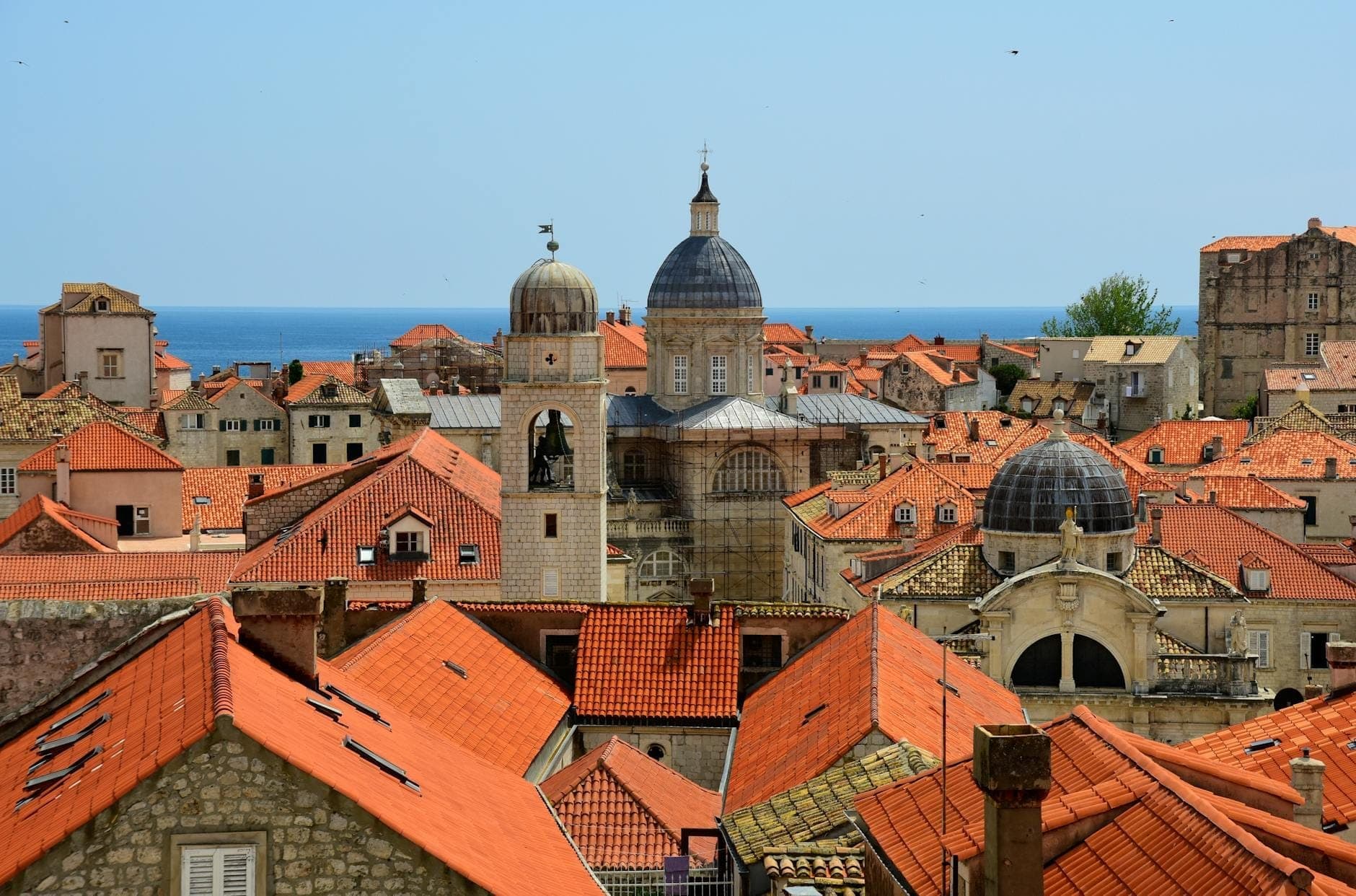 Toàn cảnh Khu Phố Cổ Dubrovnik với mái vòm Baroque nổi bật của Nhà thờ Đức Mẹ Lên Trời vươn cao trên những mái ngói đỏ và biển Adriatic phía sau.