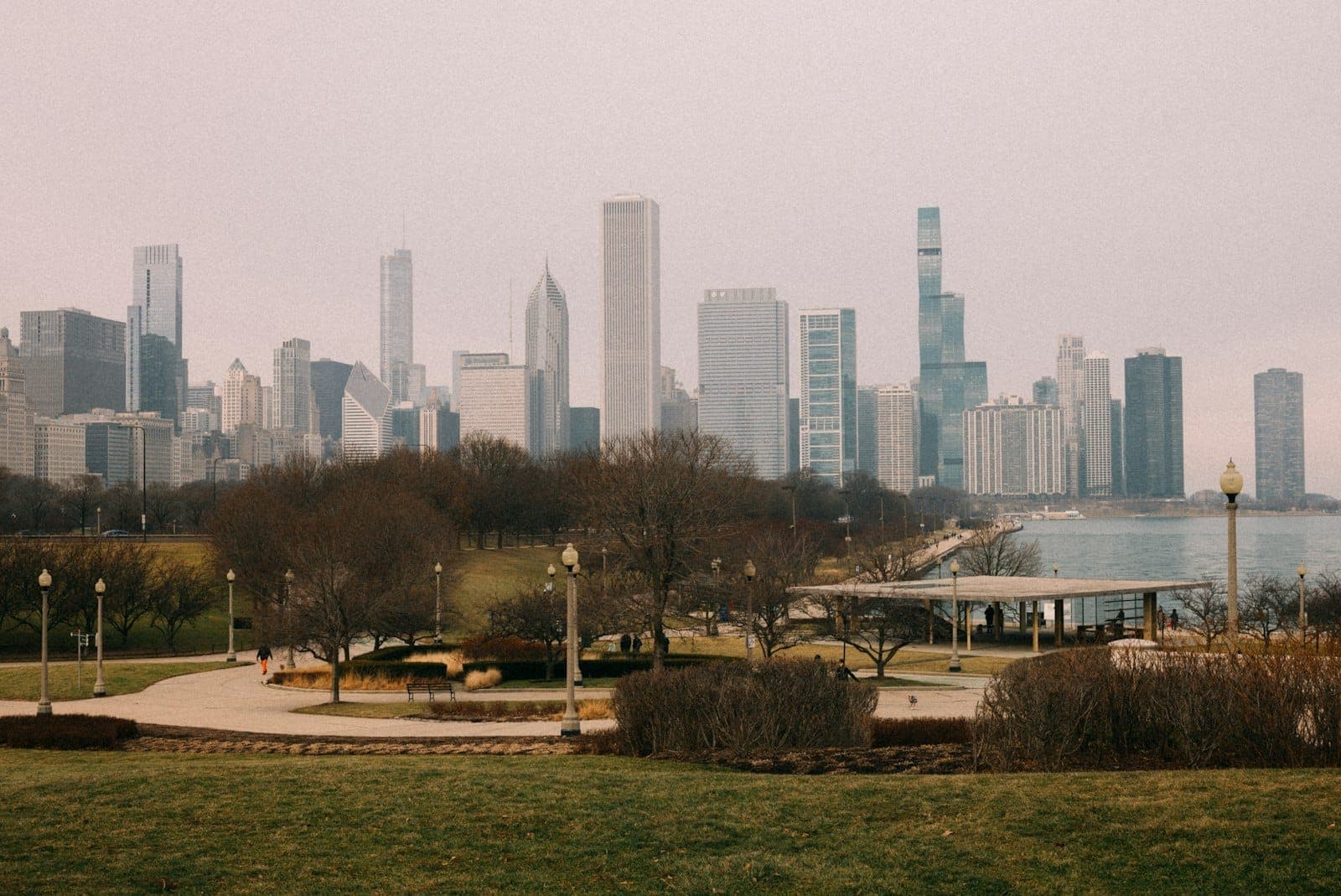 Weitwinkelansicht des Grant Park mit der Skyline von Chicago im Hintergrund, Wege, Bäume und Stadtparkinfrastruktur deutlich sichtbar.