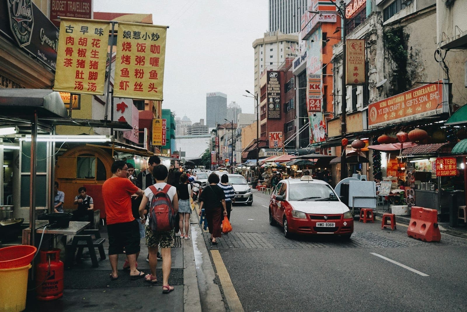 Kalye ng Chinatown Kuala Lumpur na may mga puwesto ng pagkain, mga karatulang Tsino, at masiglang pamilihan sa Petaling Street
