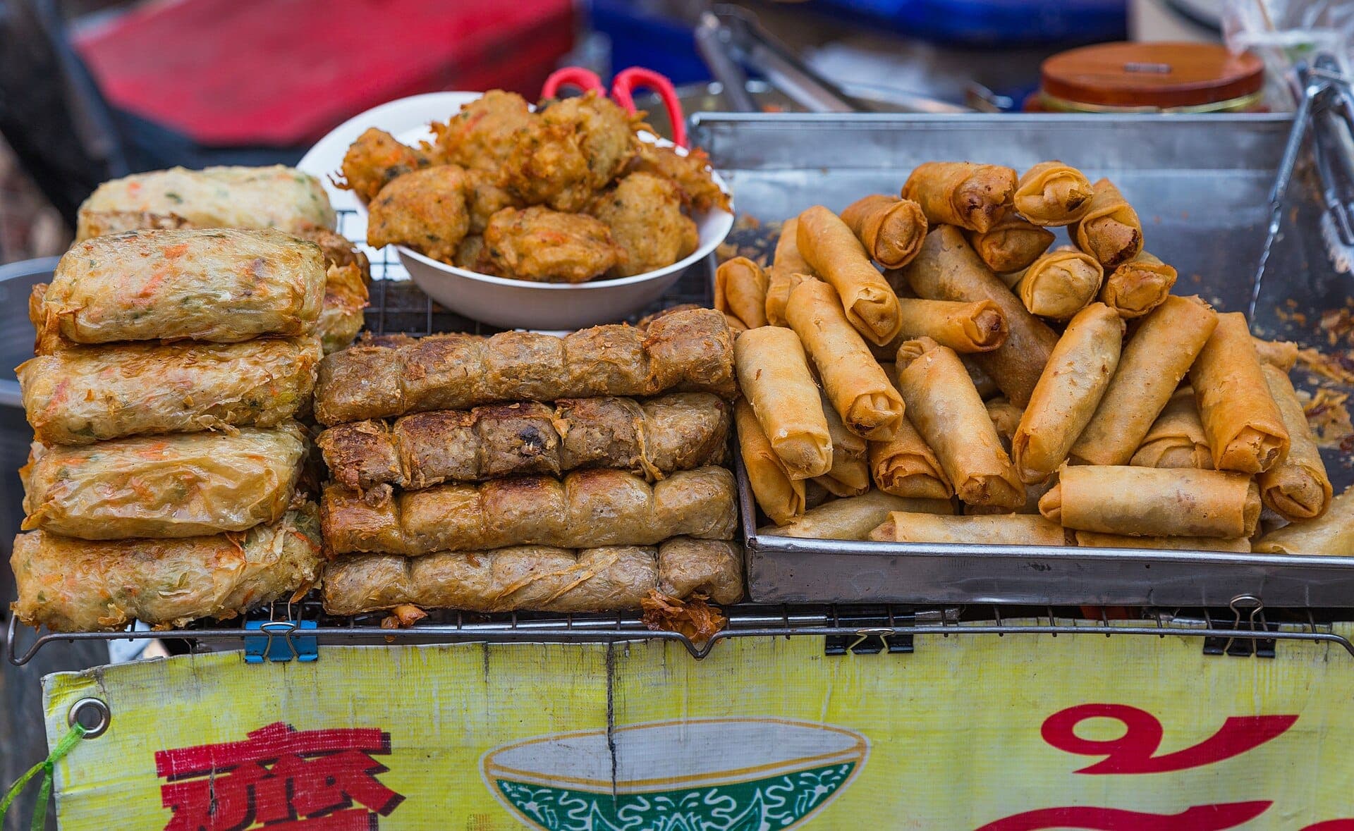 Ẩm thực đường phố Chinatown Bangkok với chả giò chiên và đồ ăn vặt tại quầy hàng địa phương