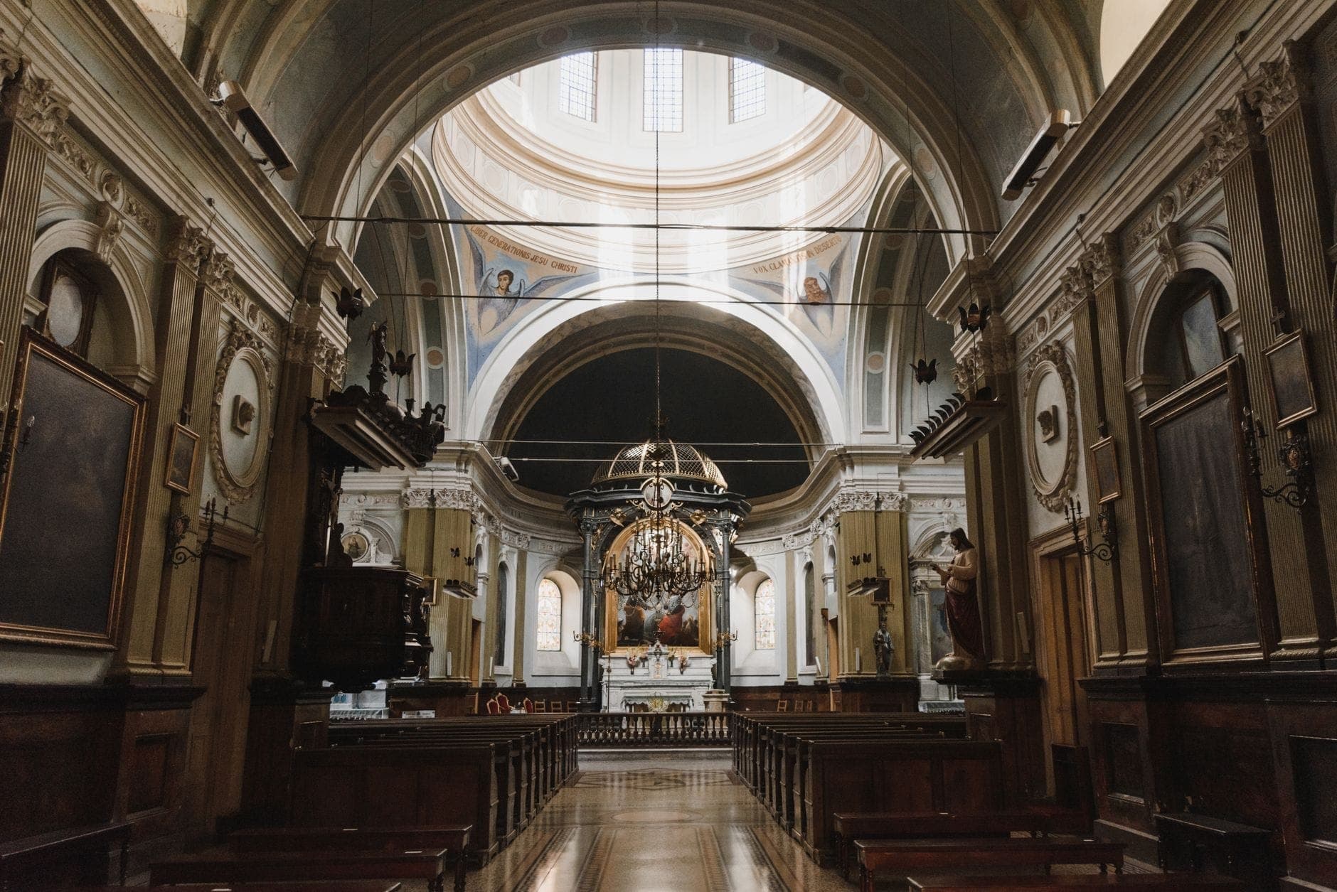 Vista della navata di una grande chiesa a Varsavia con soffitti ad arco, banchi in legno e altare in fondo, ben illuminata dalla luce naturale.