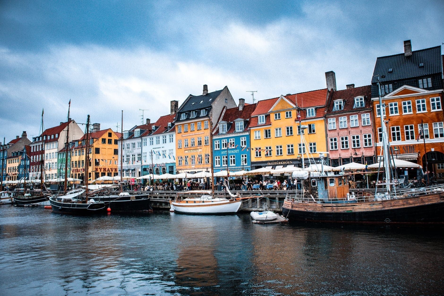 Bangunan bersejarah yang berwarna-warni dan perahu-perahu yang berlabuh di sepanjang kanal di Nyhavn, kawasan Kopenhagen yang indah dan terkenal dengan arsitekturnya.