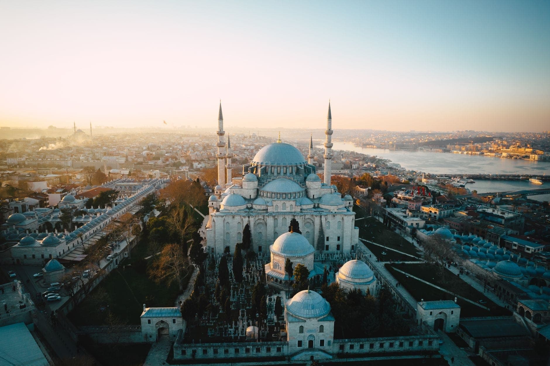 Luftaufnahme der Süleymaniye-Moschee in Fatih, Istanbul, mit Kuppeln, hohen Minaretten und der Stadt, die sich bis zur goldenen Uferpromenade erstreckt.