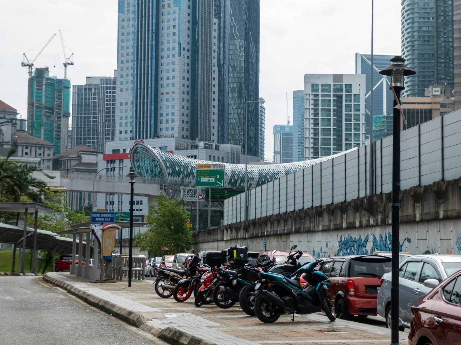 Ga MRT Kuala Lumpur sôi động với hành khách lên tàu tuyến xanh hiện đại giữa kiến trúc đô thị đương đại.