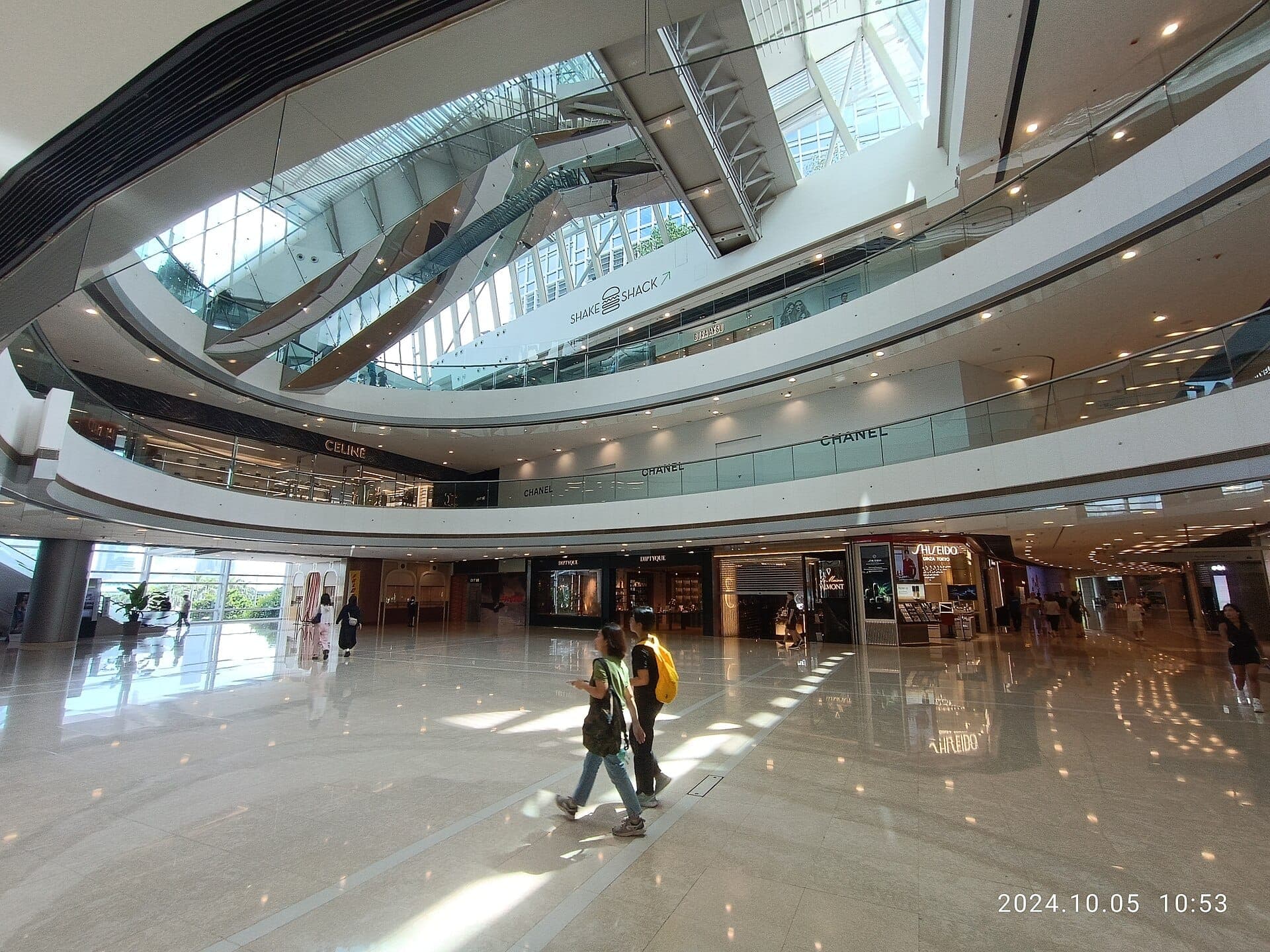 Nội thất sang trọng của IFC Mall dưới tháp kính Trung Hoàn, trưng bày cửa hàng xa xỉ và kiến trúc thép hiện đại.