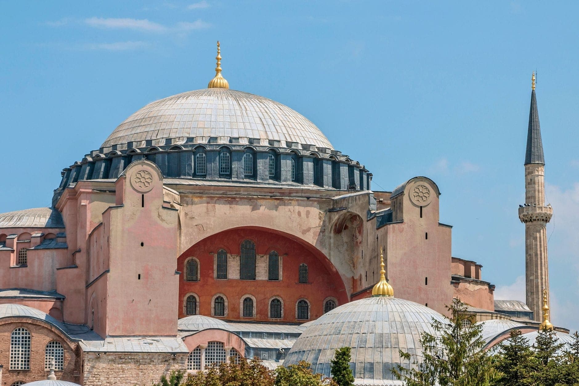 Außenansicht der Hagia Sophia in Istanbul unter strahlend blauem Himmel mit ihrer mächtigen Kuppel, den Minaretten und der byzantinischen Architektur.