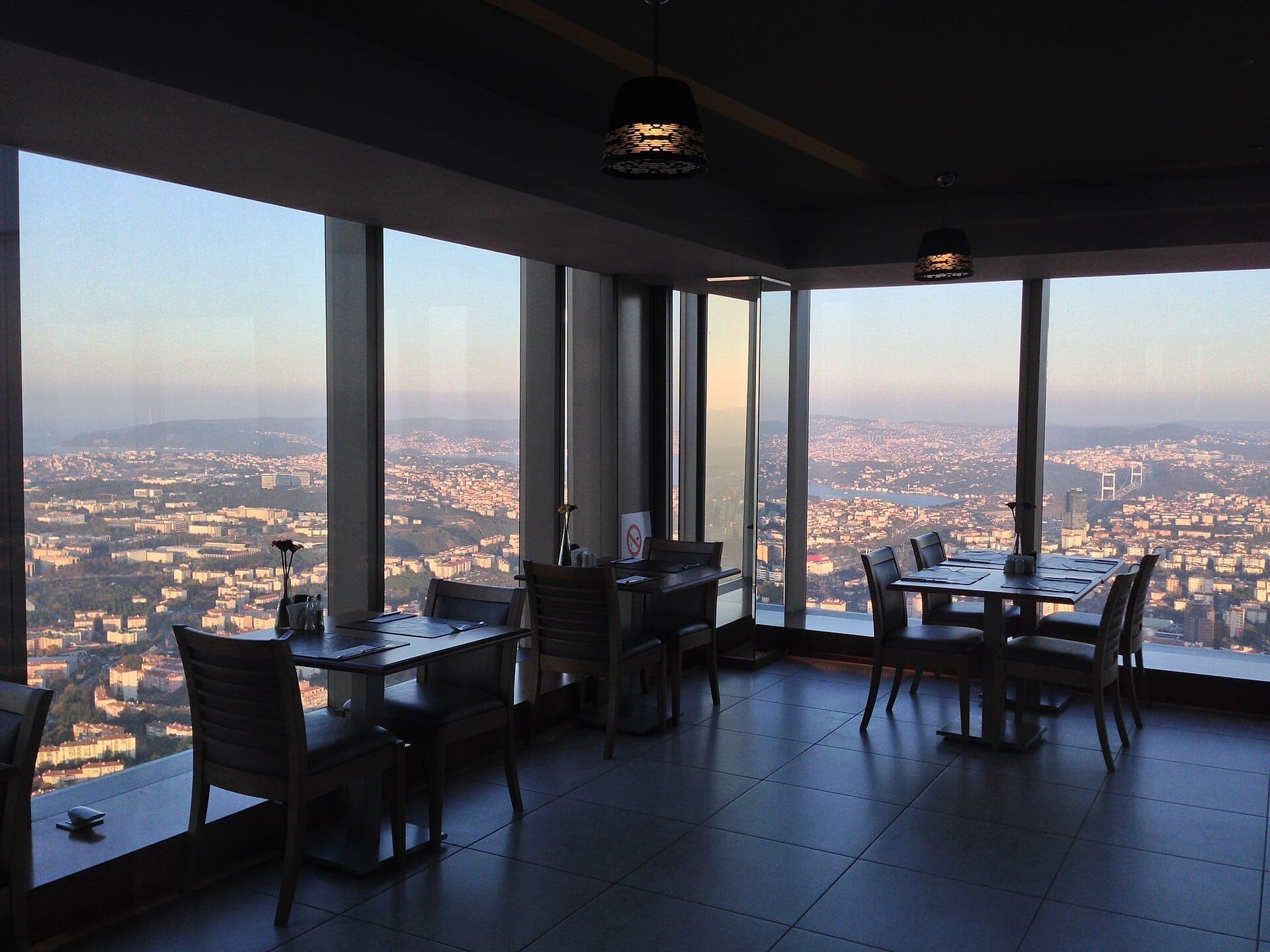 Geräumiger Innen-Sitzbereich im Istanbul Sapphire Observation Deck mit großen Fenstern, die einen weiten Blick auf die Stadtsilhouette Istanbuls und die Bosphorus Bridge bieten.
