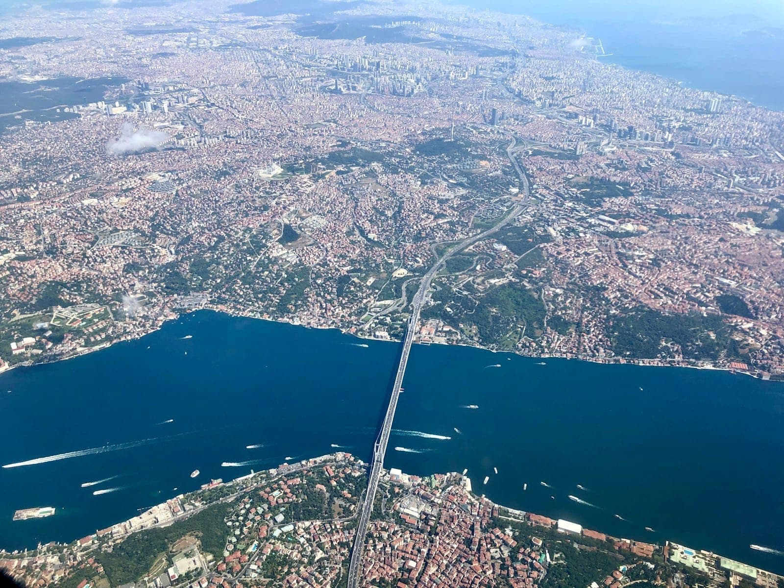 Vista aérea de Estambul mostrando el estrecho del Bósforo dividiendo la ciudad entre Europa y Asia con cielo despejado.