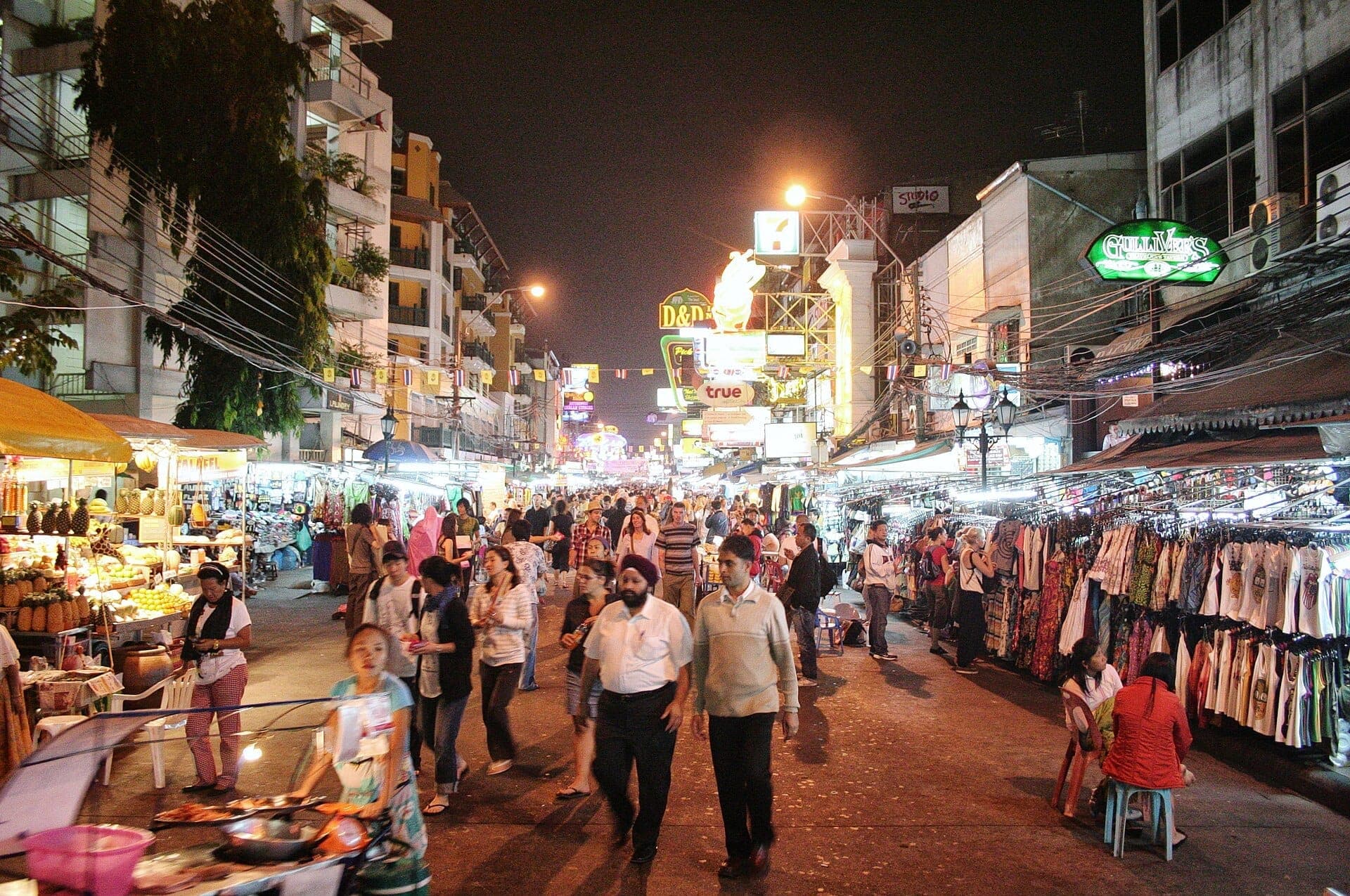 Khao San Road Bangkok về đêm với chợ đường phố nhộn nhịp, đám đông và các cửa hàng rực rỡ ánh đèn neon