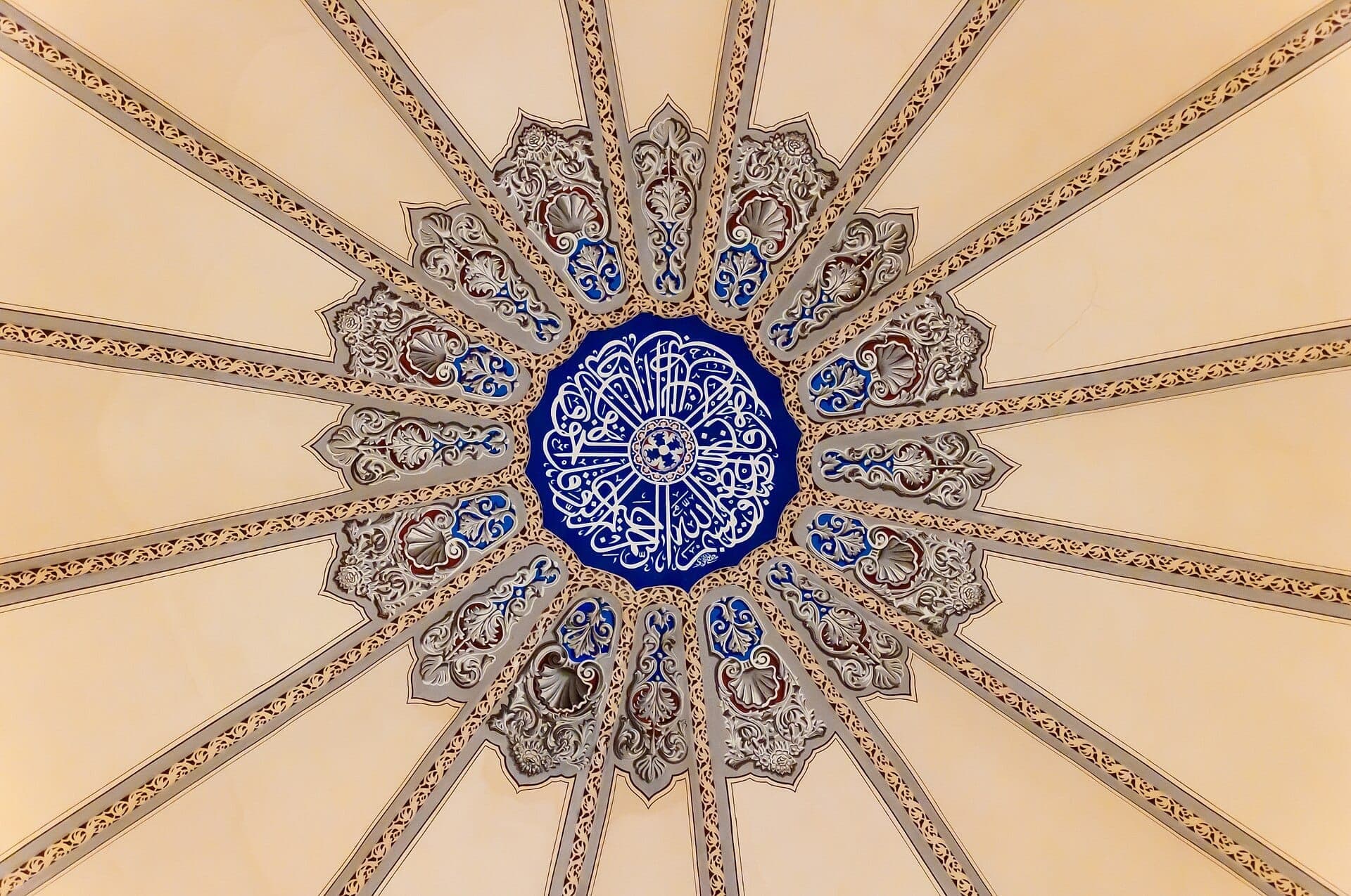 Aufwendige geometrische und florale Muster auf der Decke der zentralen Kuppel der Little Hagia Sophia Moschee in Istanbul, in den Farben Blau, Weiß und Beige.