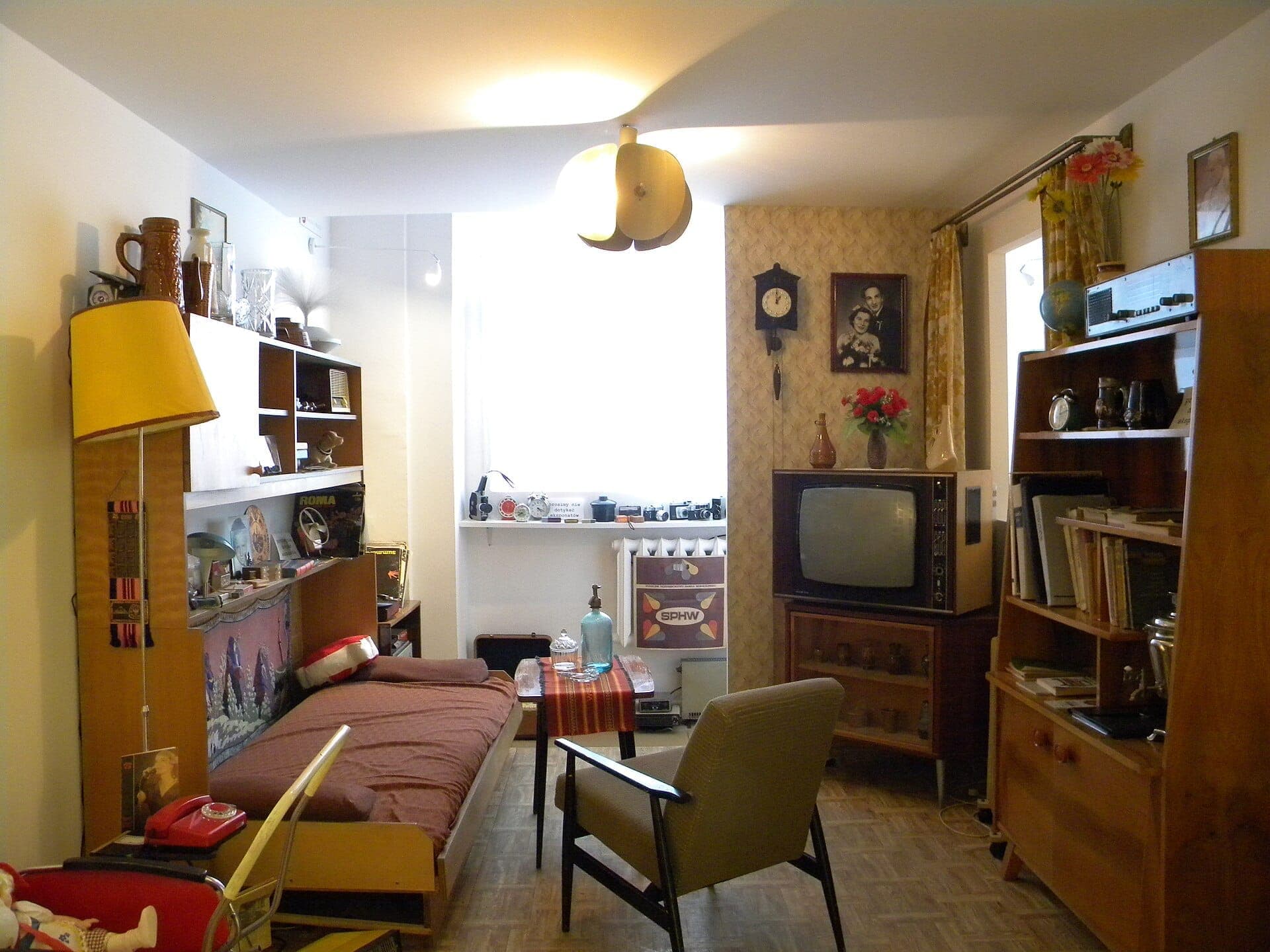 Nachbildung eines Wohnzimmers im Stil der 1970er Jahre mit braunen Möbeln, Vintage-Fernseher und Regalen im Museum Living Under Communism in Warschau.