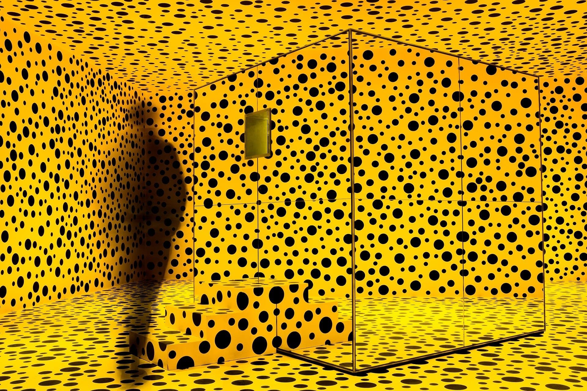 Sala gialla con pois neri al Louisiana Museum of Modern Art, con forme geometriche e una figura in silhouette.