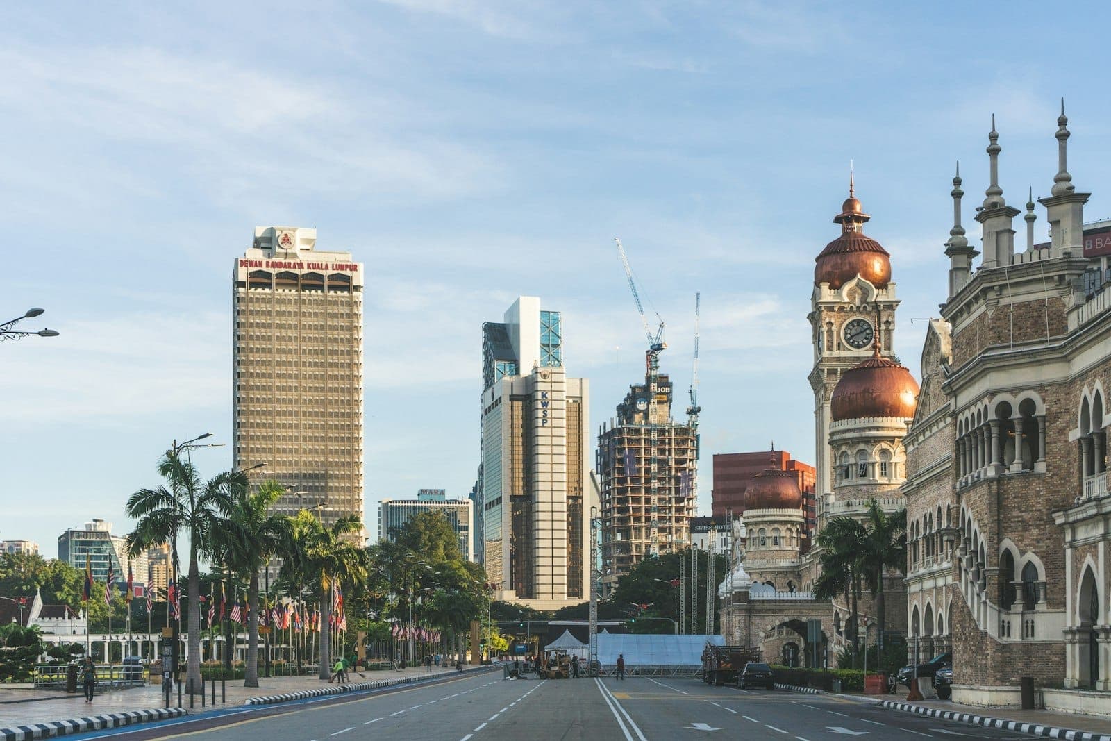 Malawak na tanawin ng Merdeka Square sa Kuala Lumpur, tampok ang kilalang Sultan Abdul Samad Building at malawak na berdeng damuhan.
