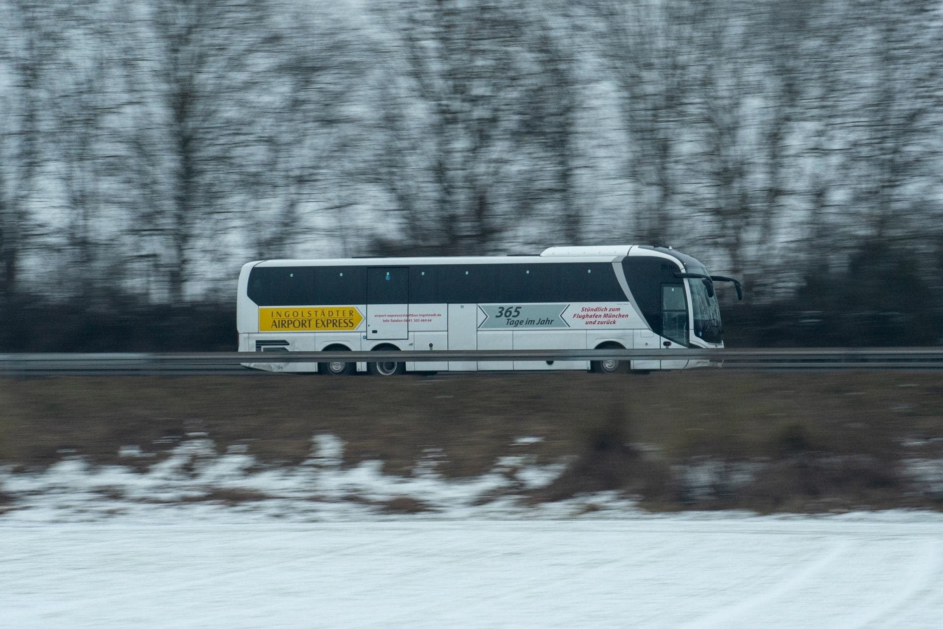 Pullman espresso dell'aeroporto in viaggio su un'autostrada in inverno, con evidente segnaletica del bus aeroportuale visibile.