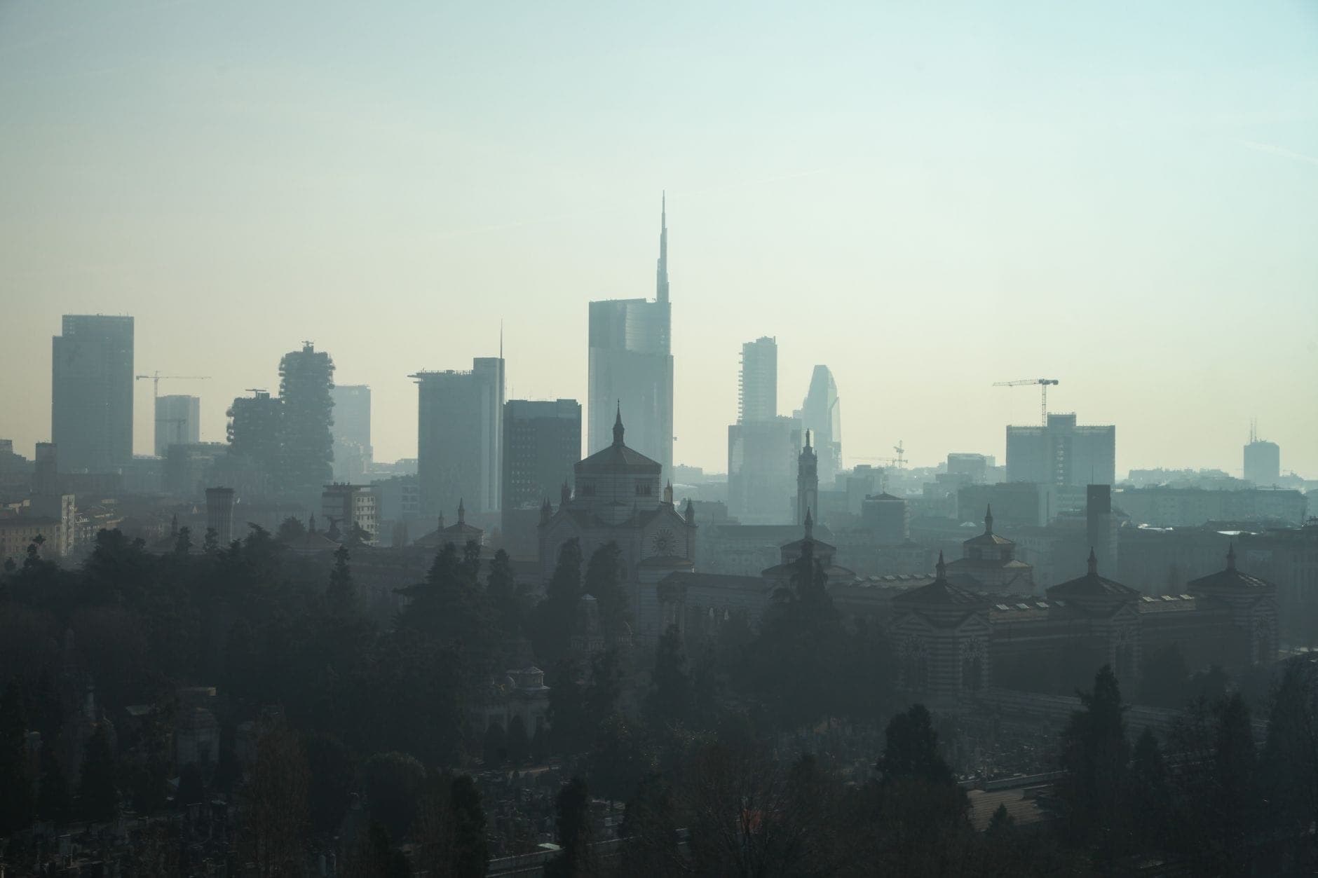 Dunstiger Winterhorizont von Mailand mit modernen Wolkenkratzern und historischen Gebäuden im nebligen Dunst.
