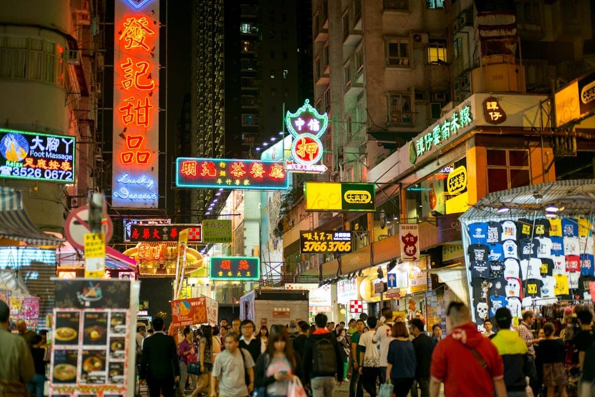 Masigla na night market sa Mong Kok sa Hong Kong na may mga neon sign at street vendor