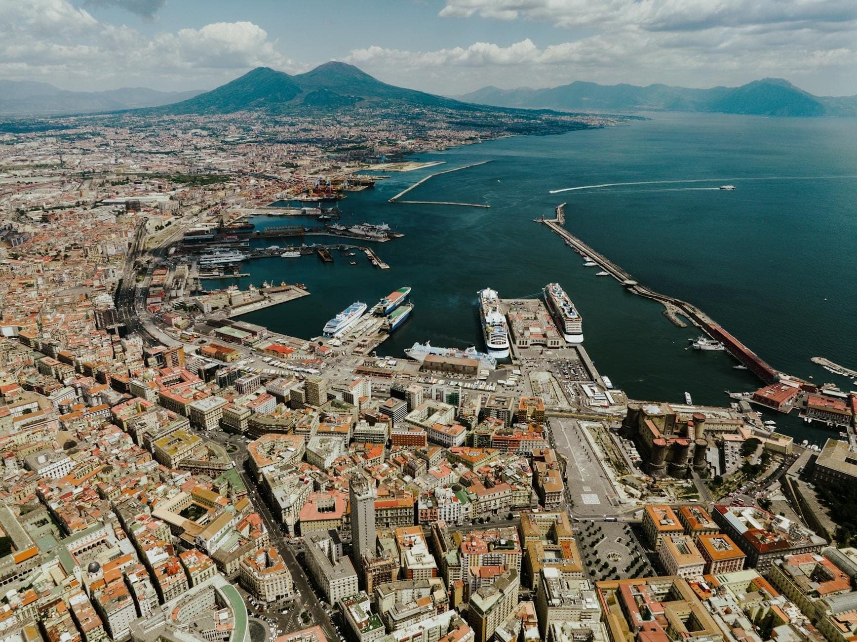 Toàn cảnh Naples nhìn từ trên cao, hiện ra các khu phố, khu cảng và núi Vesuvius ở phía xa trong một ngày trời quang đãng.