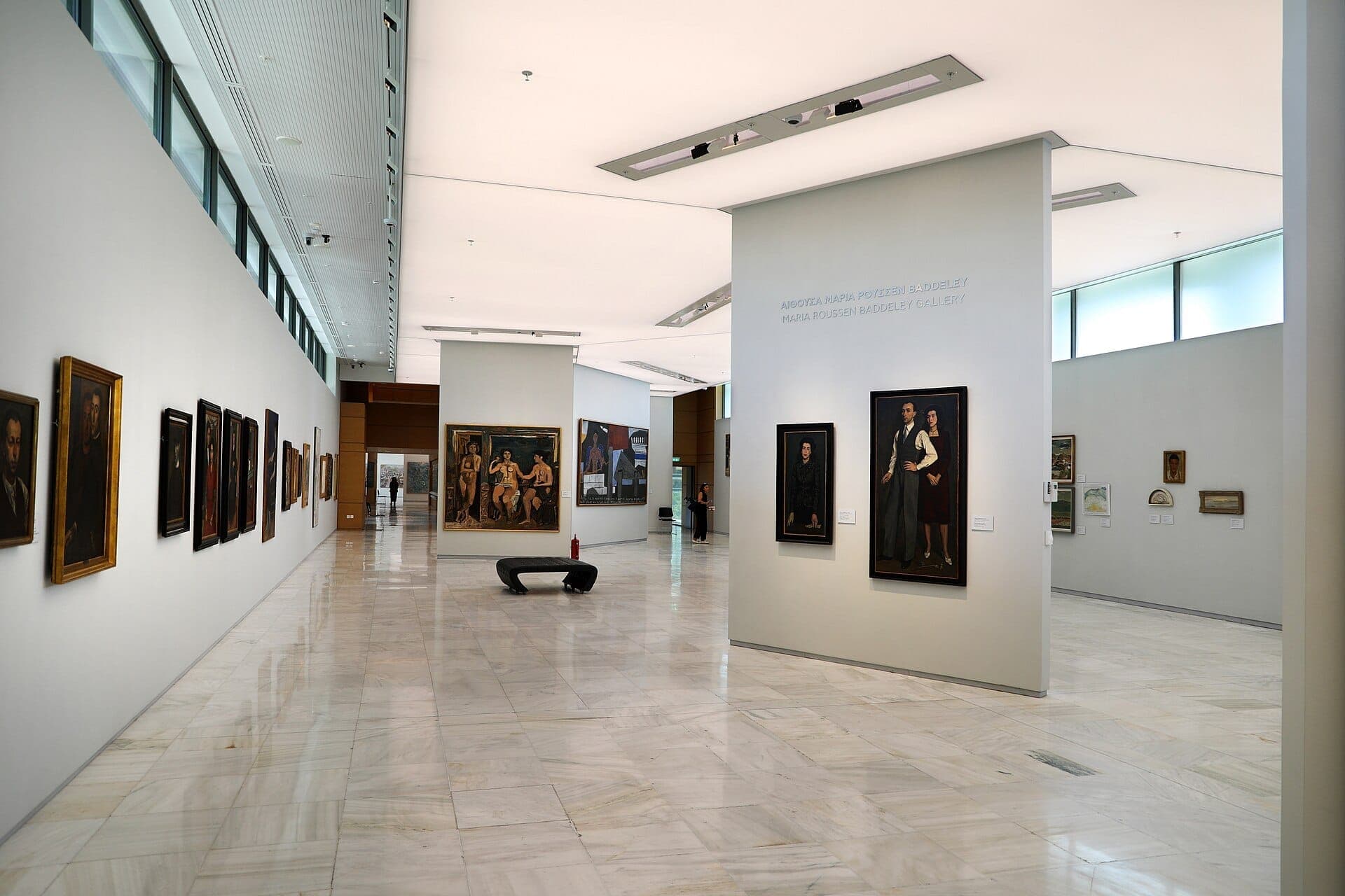 Spacious, sunlit interior of the National Gallery – Alexandros Soutsos Museum featuring modern white walls and Greek portrait paintings on display.