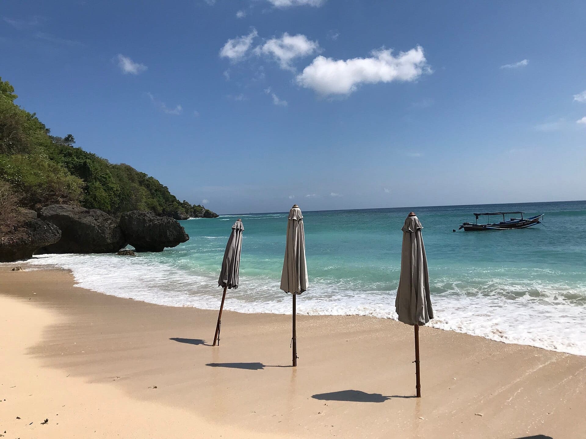 Bãi Biển Padang Padang biểu tượng ở Bali với cát vàng, nước trong Ấn Độ Dương và mỏm đá.