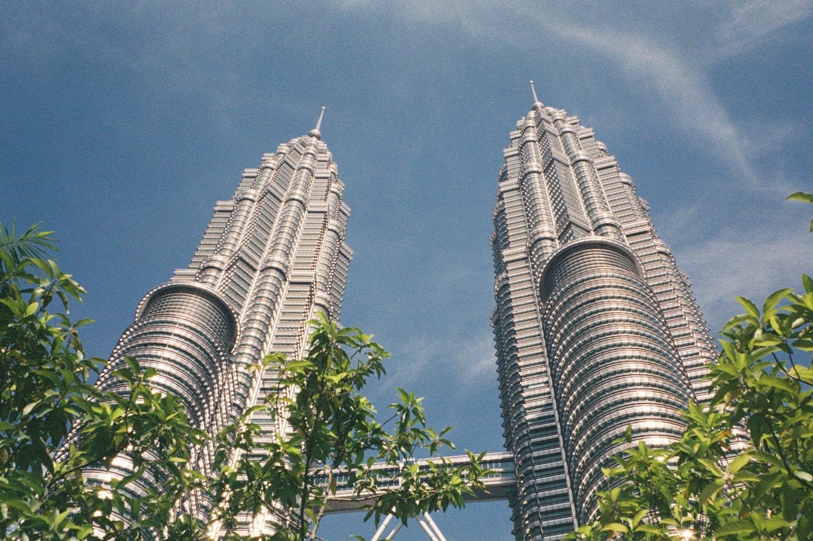 **Tháp đôi Petronas** biểu tượng vươn cao trên đường chân trời Kuala Lumpur lúc hoàng hôn, mặt ngoài thép không gỉ lấp lánh.
