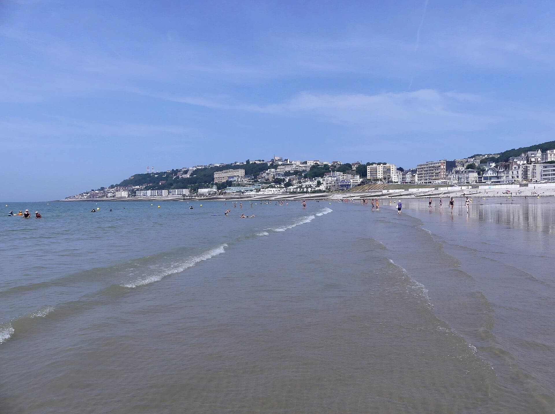 Quang cảnh Plage de Sainte-Adresse với những con sóng nhẹ nhàng, bờ cát trải dài, du khách thưa thớt và những tòa nhà của thị trấn mọc lên dọc theo sườn đồi.