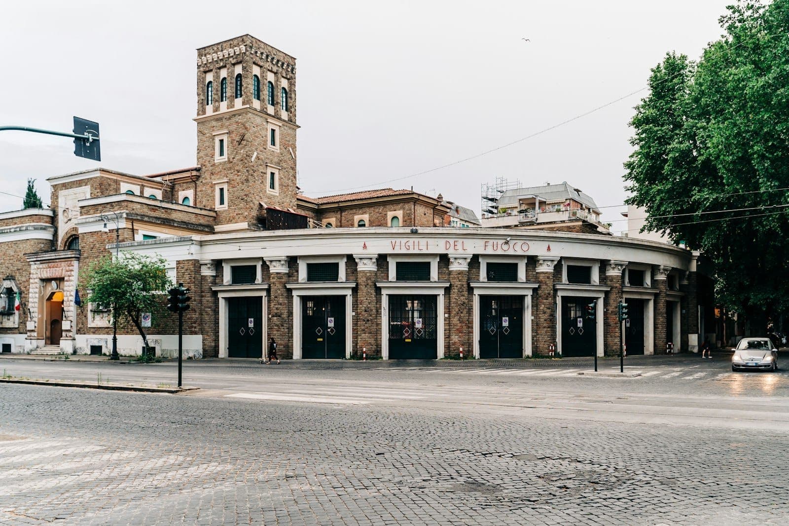 Makasaysayang gusaling ladrilyo na may natatanging bilog na harapan at tore sa Testaccio, Roma, na nagpapakita ng araw-araw na diwa ng Romano at pamana ng arkitektura ng lugar.