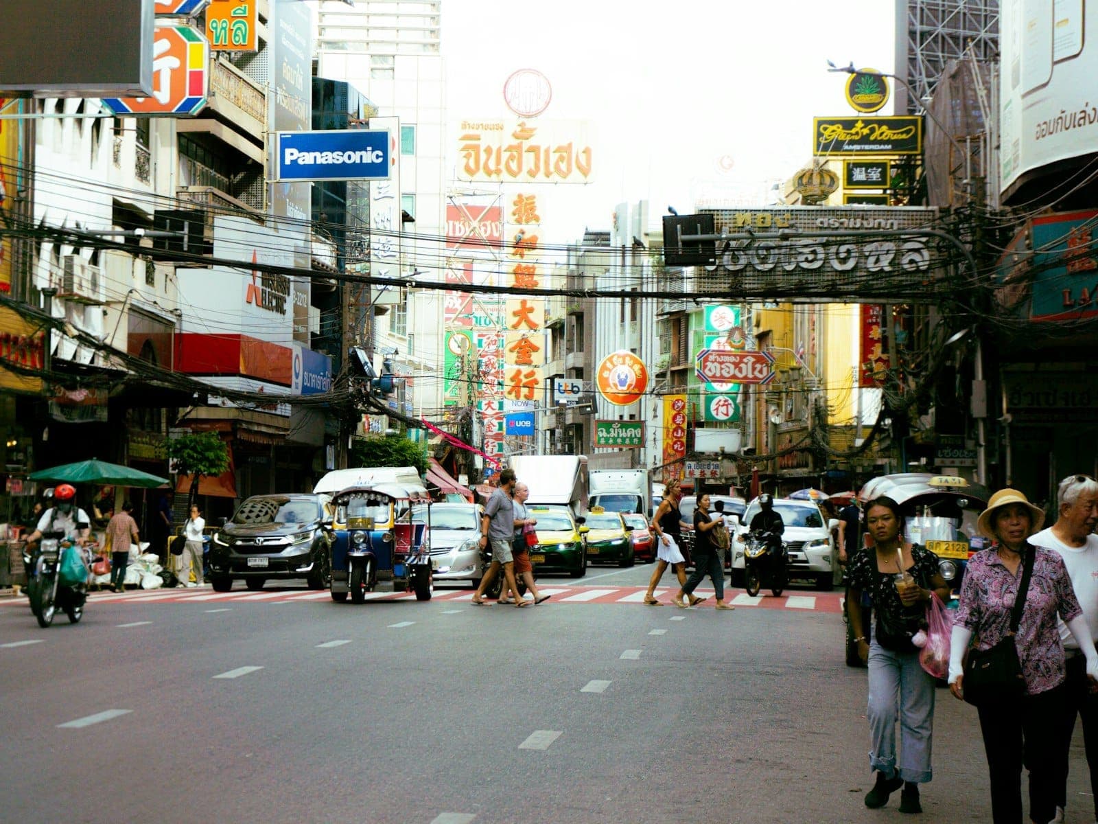 Phố nhộn nhịp ở khu phố Tàu Yaowarat, Bangkok: xe cộ, biển neon và đám đông quanh các quán ăn đường phố