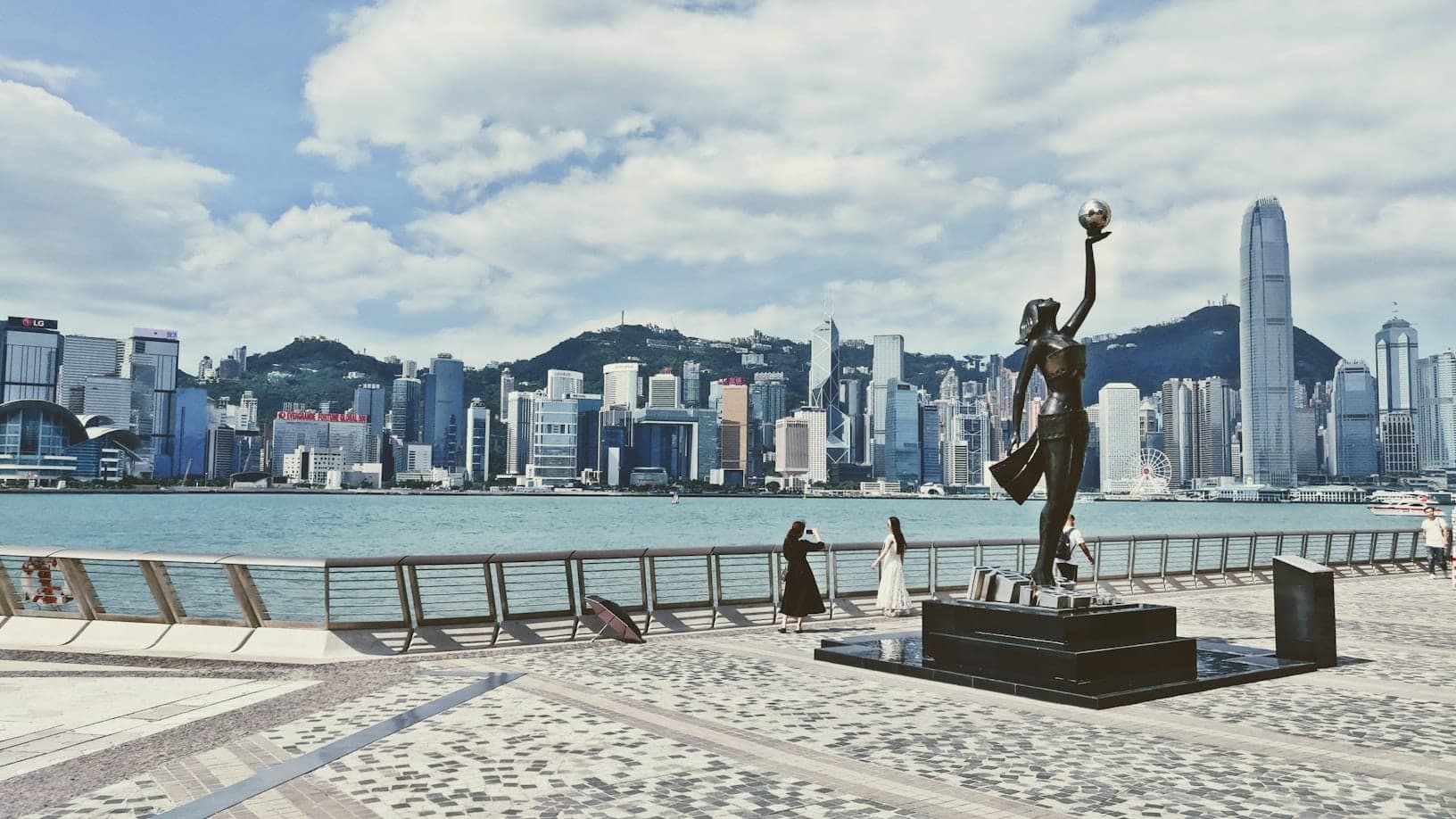 Avenue of Stars statue at Hong Kong skyline mula sa waterfront ng Tsim Sha Tsui sa Victoria Harbour