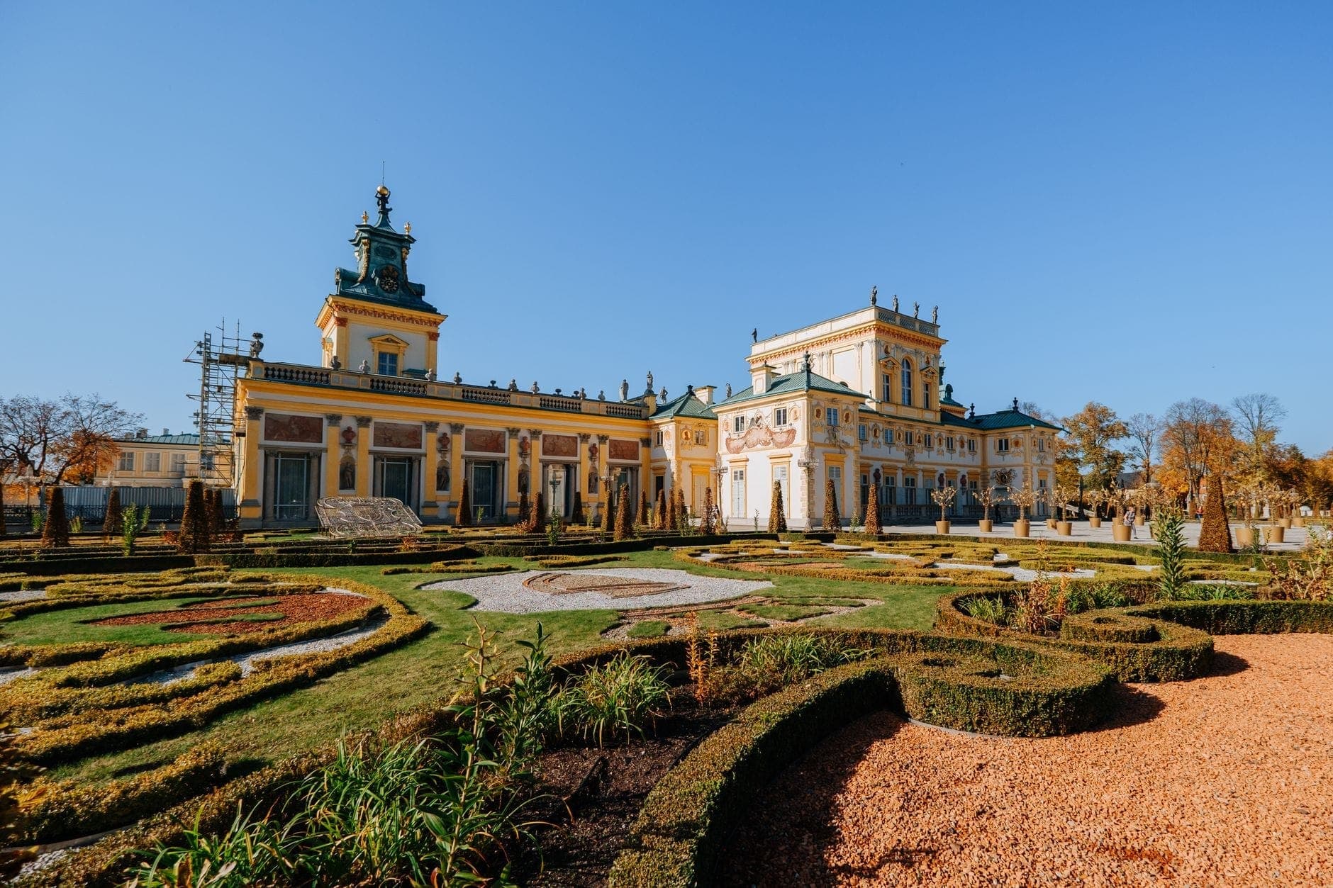 Schloss Wilanów in Warschau mit eleganten Barockgärten und klarem blauen Himmel, der die ruhige und historische Atmosphäre des Viertels zeigt.